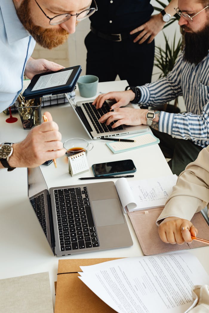 digital Teamwork in action with technology, papers, and collaboration at a dynamic office desk.